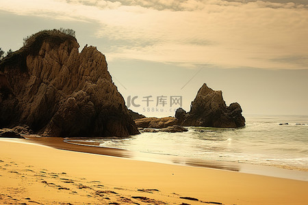 阳光明媚的天空背景图片_阳光明媚的海滩，前景是岩层