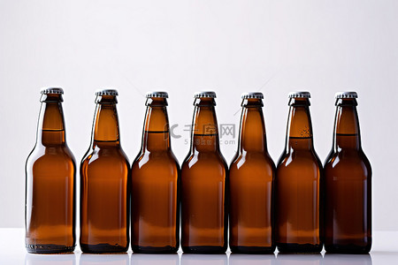 酒精瓶子背景图片_几个棕色瓶子排列在白色表面上