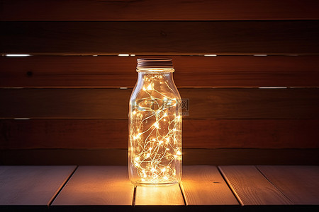 木桌上有童话灯的玻璃瓶