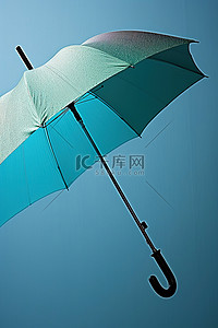 蓝色墙上的一把雨伞，上面有水滴