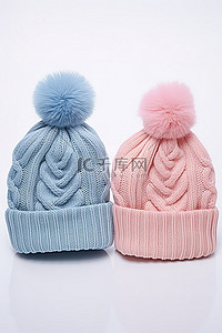 两顶帽子背景图片_两顶带有蓝色和粉色绒球的针织无檐便帽