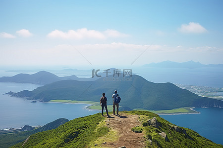 三个人站在山顶观察海洋和山脉
