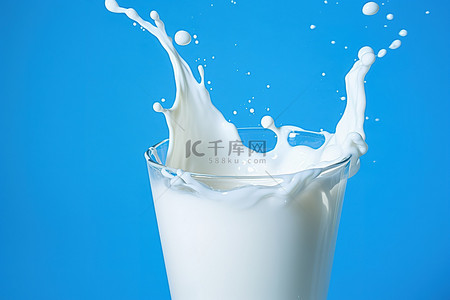 蓝色背景上的一杯牛奶，显示出飞溅的痕迹