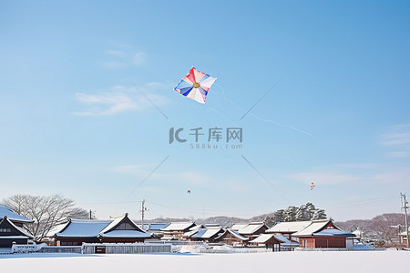 风筝在雪天飞过房屋