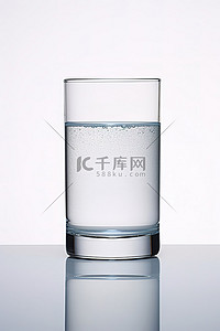 一杯水坐在桌子上和白色背景上