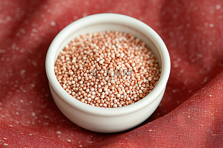 红豆薏仁山药粉背景图片_亚麻地毯上放着一小碗芝麻