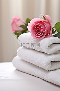 玫瑰白背景图片_白桌上的四块毛巾，中间有玫瑰