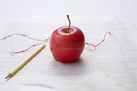 水果教育背景图片_红丝带和笔坐在白纸上的苹果