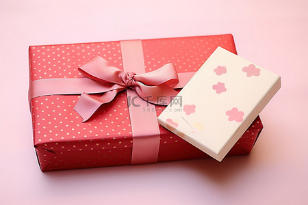 波尔卡圆点背景图片_信封旁边的粉红色礼品盒