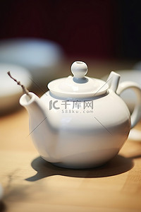 桌子上放着一个白色的小茶壶