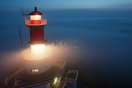 起起背景图片_一座灯塔在雾中亮起