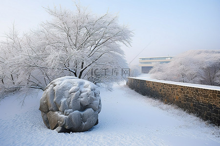 冬日的背景图片_一块被白雪覆盖的冰冻石头俯瞰着冬日的雪景