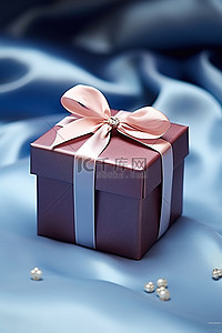 圣诞节背景图片_坐在缎子上的蓝色礼品盒