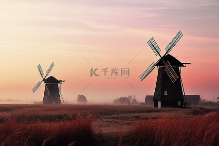 生态山景背景图片_日落时，两座风车矗立在草地上