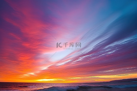 五彩斑斓背景图片_在海洋上方可以看到五彩斑斓的天空，伴随着波浪