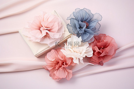 三朵粉红色的蓝色和白色的花朵坐在粉红色的织物上