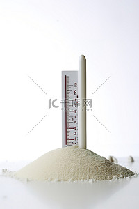 白色背景照片背景图片_白色背景照片中沙子中的温度计