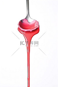 白色背景上的勺子里涌出红色液体