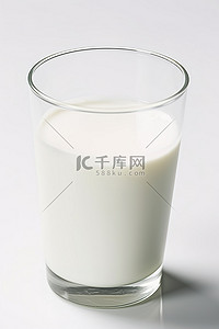 牛奶在一个白色表面的玻璃杯中