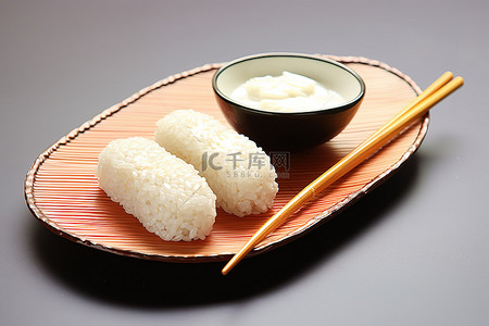吃饭用筷子背景图片_饭团和筷子放在盘子里