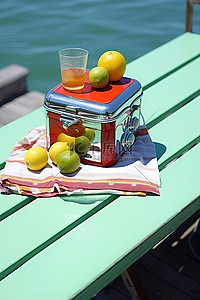橙色夏天背景图片_这张长凳上有一个橙色冷却器，里面有水和一些水果