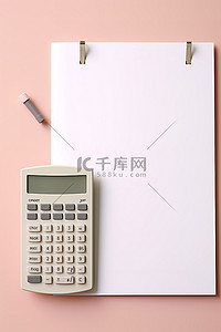 一个计算器和一个信封，放在另一张纸上，上面覆盖着回形针