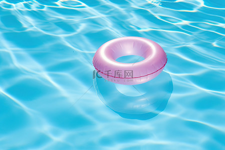 粉色星背景图片_蓝色海洋游泳池中漂浮的粉色星环