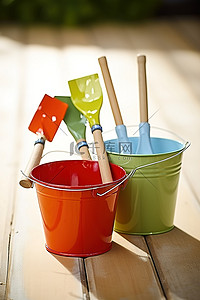 pc水桶背景图片_木桌上放着四个彩色水桶和铲子