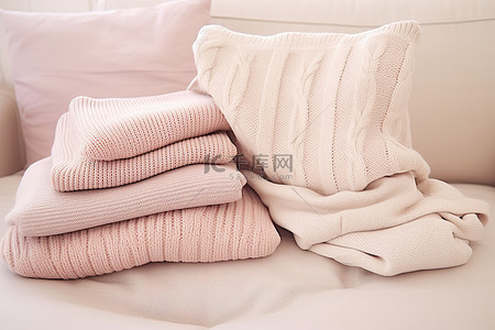 沙发上的三件淡粉色毛衣