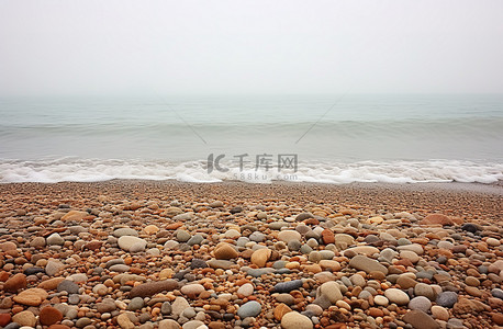 海滨浴场背景图片_布满鹅卵石和海浪的海滨海滩