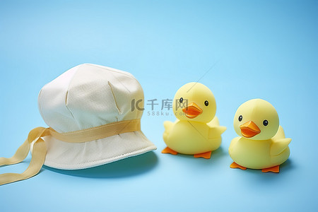 橡皮背景图片_三只小橡皮鸭围绕着蓝色背景的帽子