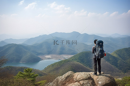 攀登人背景图片_背着背包在山上俯瞰山水的男人