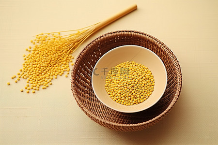 一个柳条篮，里面有两个碗，里面装满棕色谷物和一根稻草