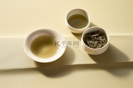 绿茶茶叶背景图片_盘子上放着两小盘绿茶