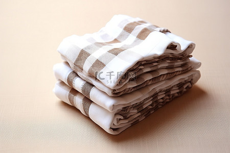 折叠毛巾背景图片_四张餐巾用格子布折叠在桌子上