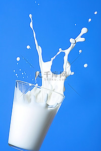 牛奶从蓝色背景的玻璃杯中倒出