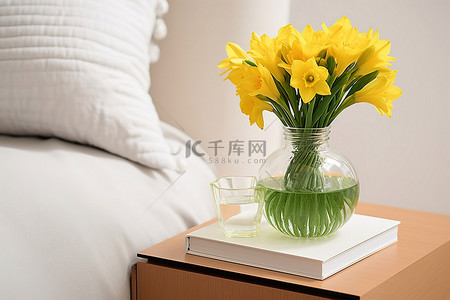 床头柜上一本旧书旁边花瓶里的黄色水仙花