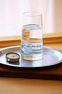 就背景图片_桌子上的一杯水和胶带就在秤旁边