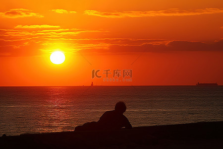 日落时，一个男人躺在海滩上