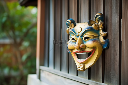 初二回门背景图片_木屋旁的栅栏上有一个亚洲小面具