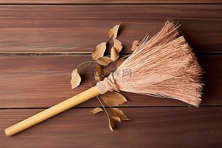 扫地小帮手背景图片_木质表面上有棕色纸叶和棉签的小扫帚