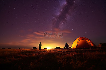 夜晚帐篷背景图片_人们在营地附近的一片带有帐篷的田野里在星空下露营