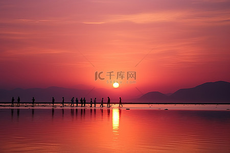 站在背景图片_人们站在水面上看夕阳西下