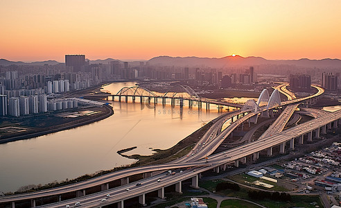 江边日落背景图片_日落时现代城和城市大桥的鸟瞰图