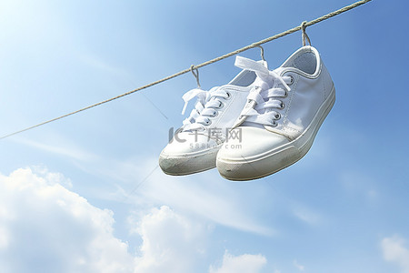 绳子背景图片_白色运动鞋挂在天空的绳子上