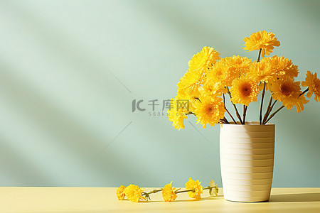 桌上的小白色花瓶，插着黄色的花