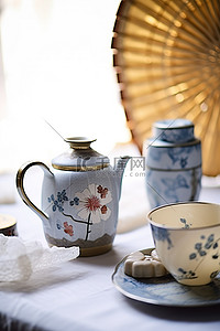 茶壶盘子风扇和其他物品放在白色表面上