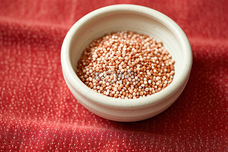 红豆薏仁山药粉背景图片_亚麻地毯上放着一小碗芝麻