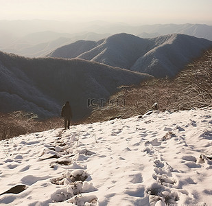 一名男子站在某地区一座白雪覆盖的山上