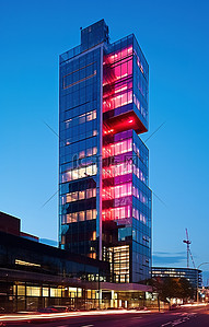 一栋设有办公室和灯光的玻璃建筑在夜间亮起